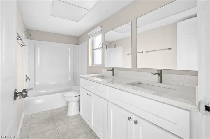 Bathroom featuring  shower combination and double vanity