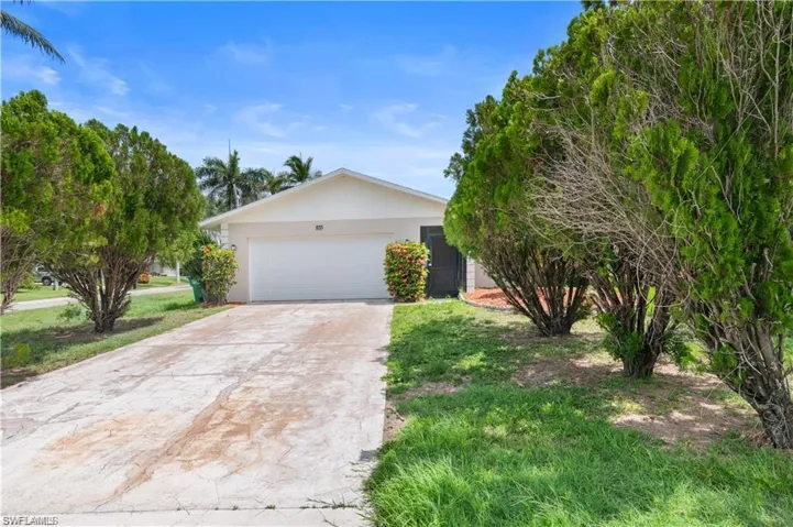 View of front of house with driveway and stucco siding