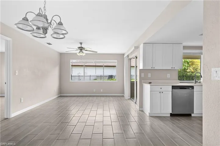 Kitchen featuring white cabinetry, light countertops, dishwasher, a chandelier, and wood finish floors