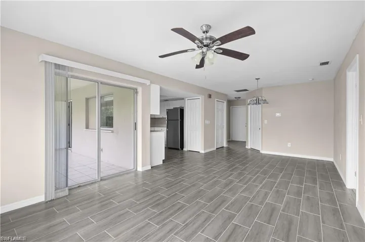 Unfurnished living room with ceiling fan and wood finish floors