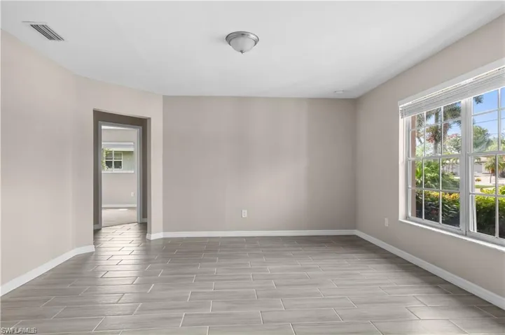 Unfurnished room featuring wood finish floors and healthy amount of natural light