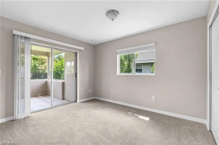 Unfurnished bedroom with light carpet, access to exterior, and a closet