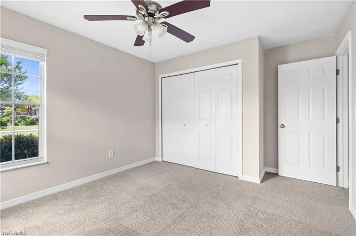 Unfurnished bedroom with carpet flooring, a closet, and a ceiling fan