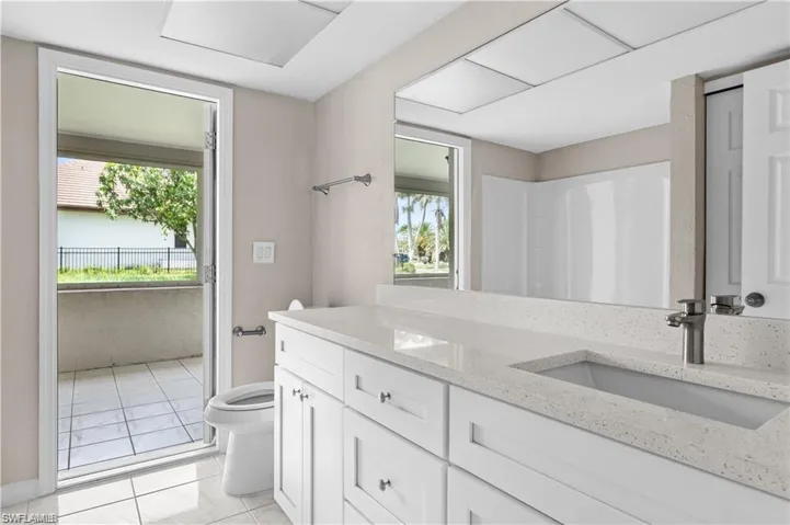 Bathroom featuring vanity, light tile patterned flooring, and healthy amount of natural light