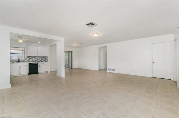 Unfurnished living room featuring ceiling fan, light tile patterned floors, and plenty of natural light