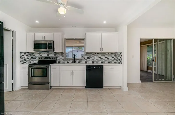 Kitchen featuring stainless steel appliances, light countertops, healthy amount of natural light, and backsplash