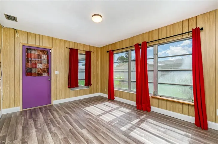 Spare room featuring wood finished floors and wooden walls
