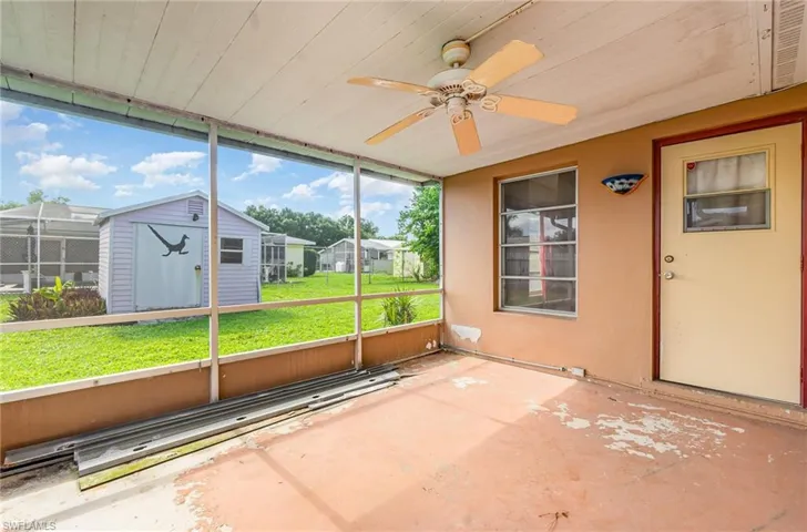 Unfurnished sunroom with a ceiling fan and a residential view