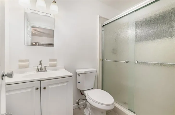 Full bathroom featuring vanity, a shower with shower door, and tile patterned flooring