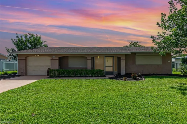 Ranch-style house with stucco siding, an attached garage, and concrete driveway