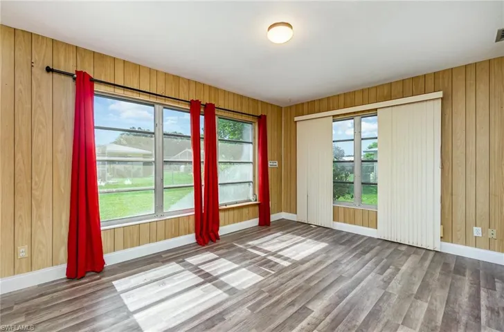 Unfurnished room with wood finished floors and wooden walls