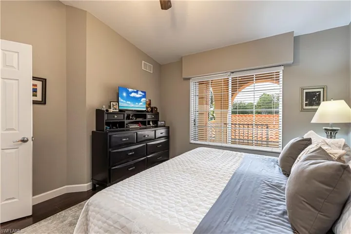 Room featuring rich wood-finish flooring and a vaulted ceiling