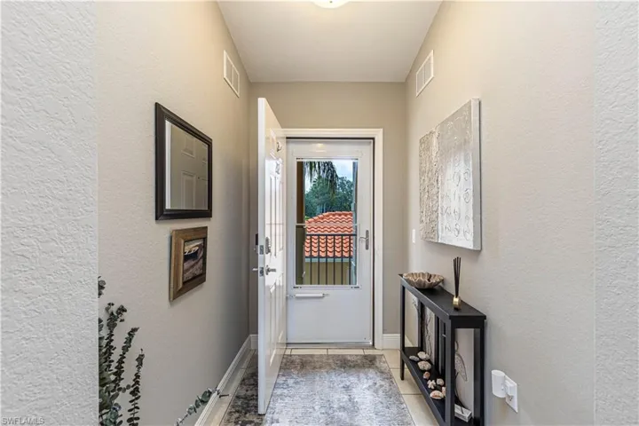 Entryway featuring neutral wall tones, white trim, and tile flooring