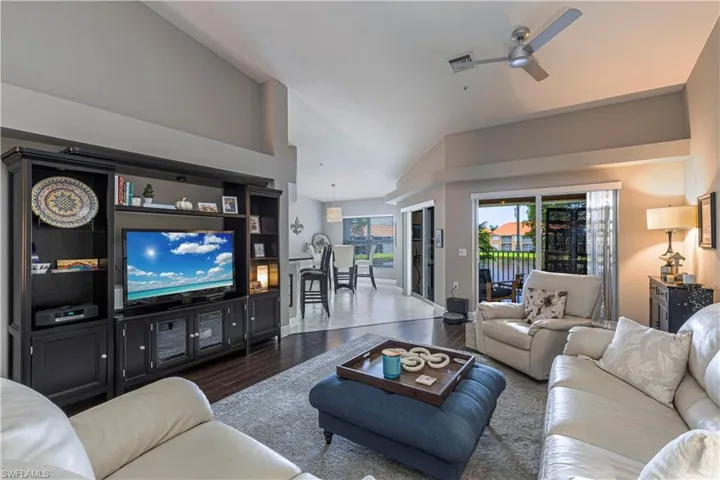 Living area featuring dark wood-finish flooring, a contemporary ceiling fan, and sliding glass doors opening to an outdoor space