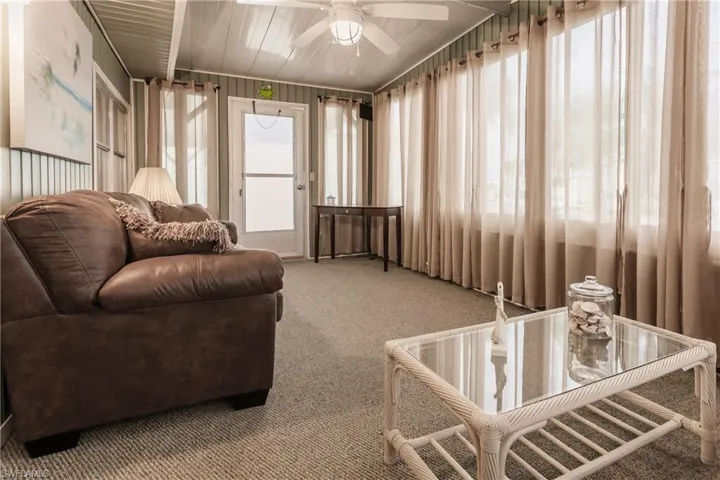 Florida room with carpet flooring, ceiling fan, and exterior door