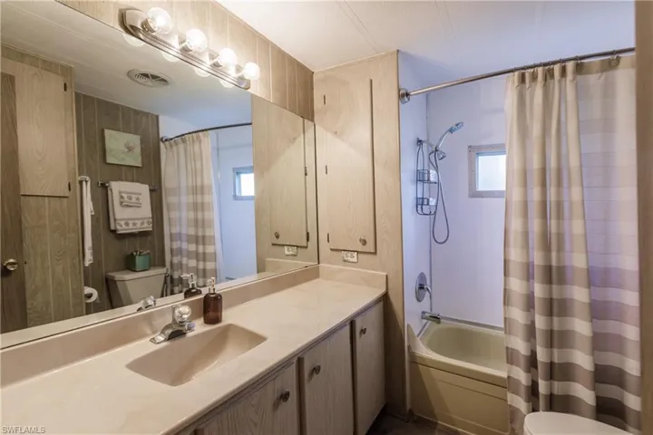 Full bathroom featuring vanity, shower / tub combo, and toilet