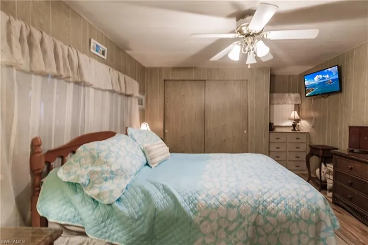 Bedroom oasis with a closet, ceiling fan, and light laminate / wood-style floors