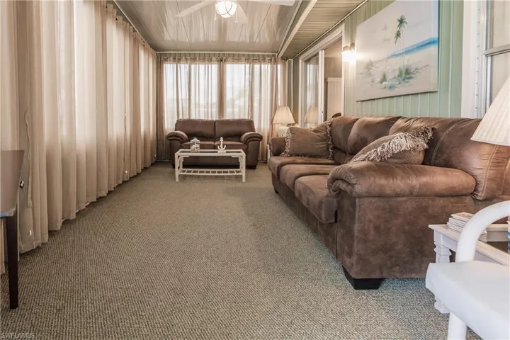Carpeted Florida room featuring ceiling fan