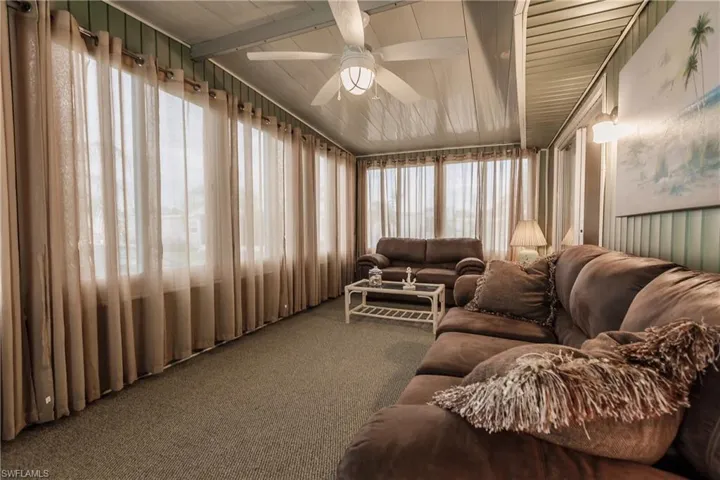 Sunroom / Florida Room with lofted ceiling with beams and ceiling fan