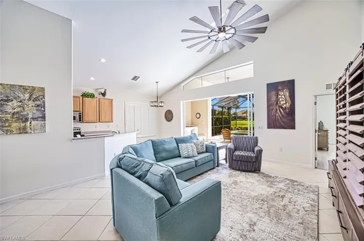 Tiled living room with high vaulted ceiling and an inviting chandelier