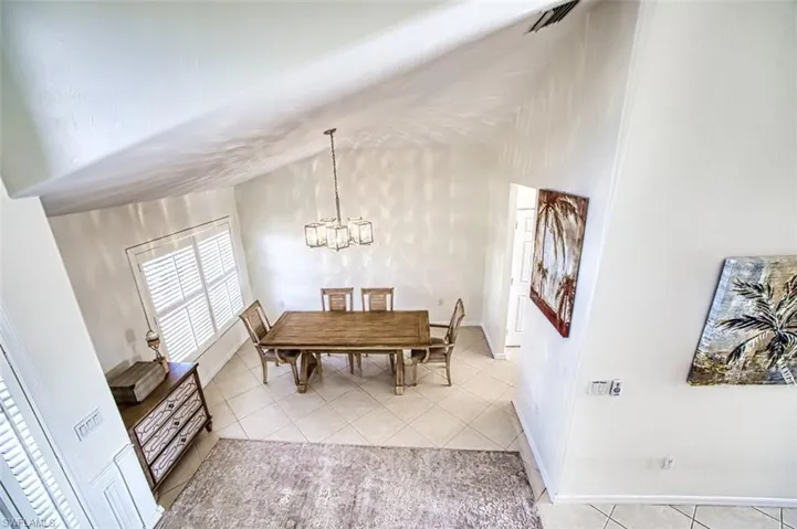 Tiled dining space featuring an inviting chandelier