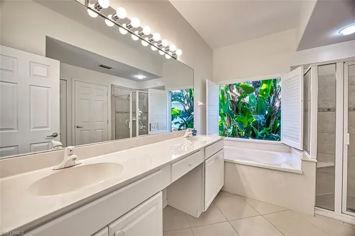 Bathroom with plus walk in shower, tile patterned flooring, and vanity