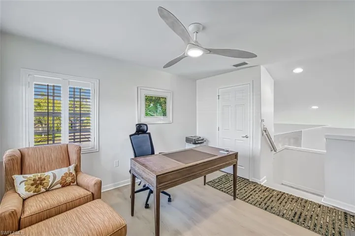 Home office with light hardwood / wood-style floors and ceiling fan