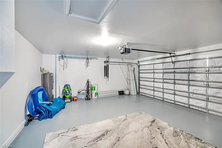 Garage featuring a garage door opener and water heater