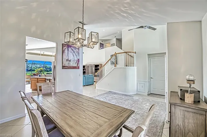 Dining room featuring a notable chandelier, a towering ceiling, and light tile patterned floors