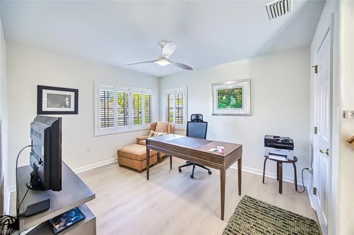 Home office with light wood-type flooring and ceiling fan