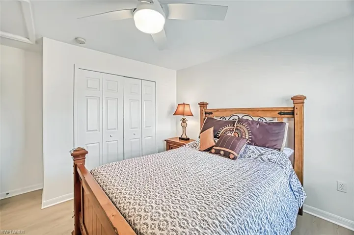 Bedroom with ceiling fan, light wood-type flooring, and a closet