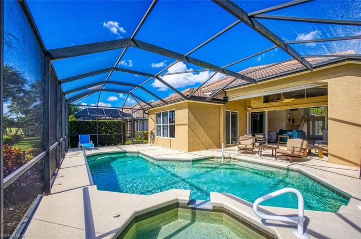 View of pool with ceiling fan, glass enclosure, a patio area, and an in ground hot tub