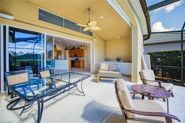 View of patio featuring glass enclosure and ceiling fan