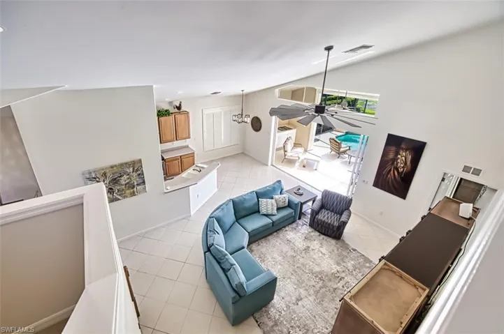 Tiled living room with vaulted ceiling and ceiling fan