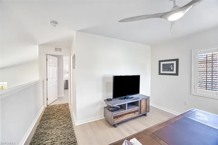Living room featuring ceiling fan and light hardwood / wood-style flooring