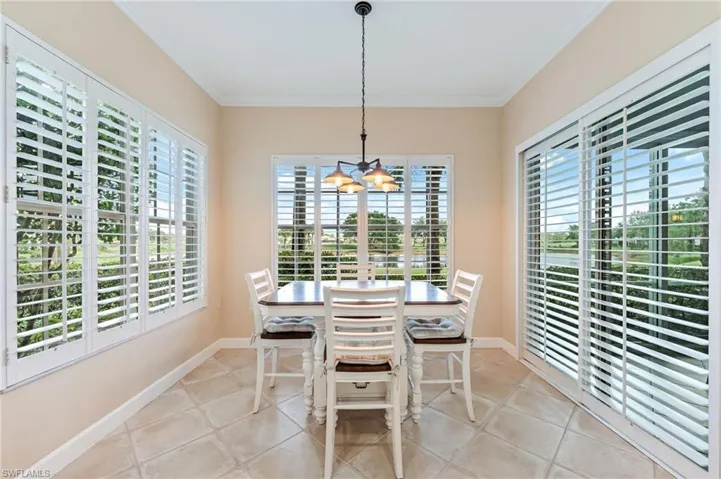 Breakfast room featuring a chandelier, crown molding, and a healthy amount of sunlight
