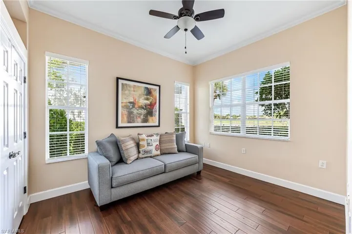 Bedroom with dark wood-style flooring, baseboards, a ceiling fan, and crown molding