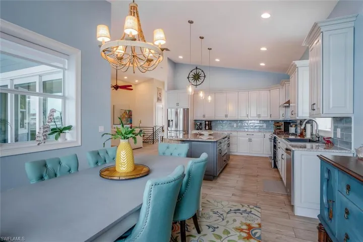 Kitchen featuring Kitchen Maid  cabinetry, hanging light fixtures, a kitchen island, appliances with stainless steel finishes, and backsplash