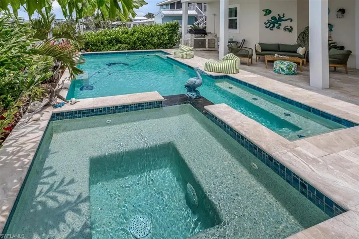 View of pool with a patio, an outdoor living space with build in kitchen, and an in ground spa