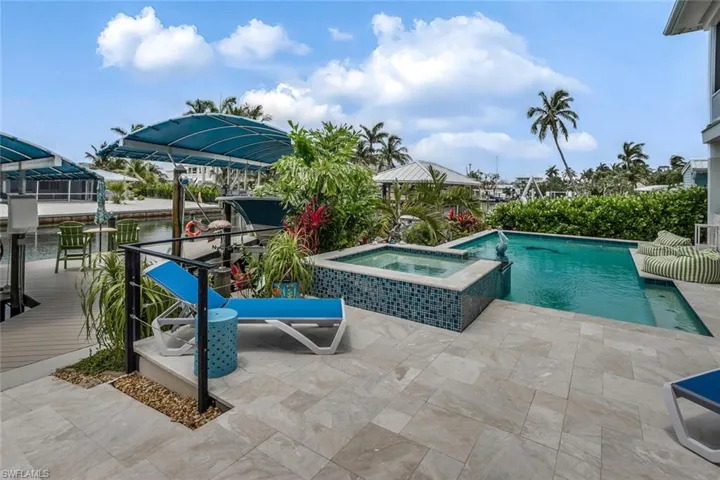 View of pool with a patio and an in ground spa and covered boat lifts
