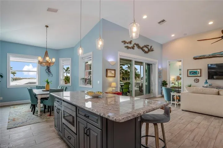 Kitchen featuring stainless steel drawer microwave, porcelain plank tile floors, a breakfast bar area, and pendant lighting