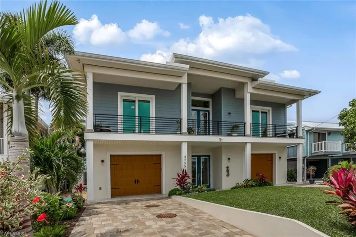 Front elevation of home featuring two garages and a balcony