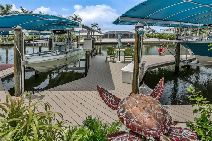 Dock area with a water view of canal featuring two covered boat lifts