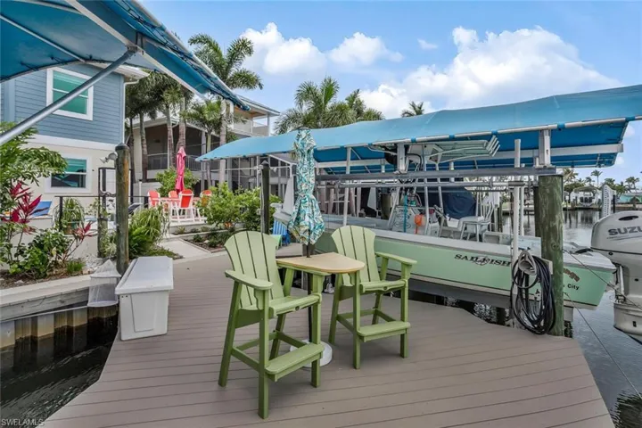 View of synthetic lumber dock featuring two boat lifts and room for seating over canal
