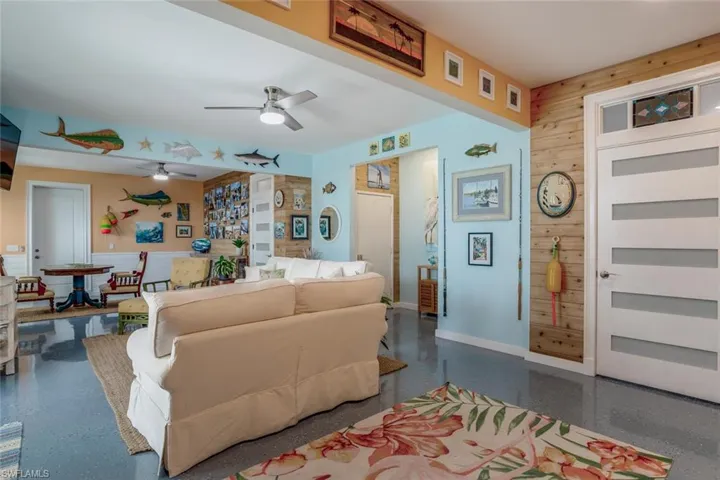 Ground bonus room with ceiling fan, epoxy floor and cedar shiplap walls