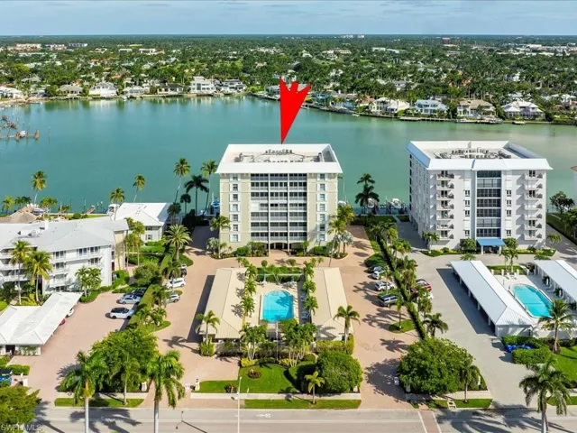 Aerial view of a pool and a nearby body of water