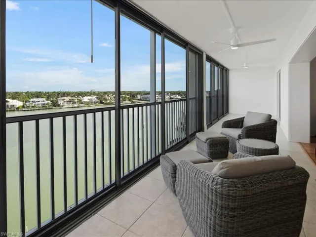 Balcony featuring a water view and a ceiling fan