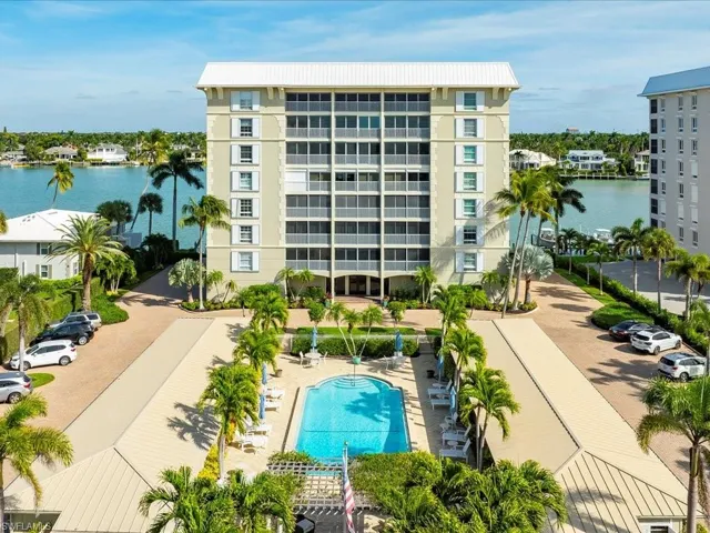 View of apartment building / complex with a water view and a community pool