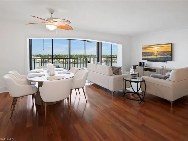 Dining area featuring wood finished floors, crown molding, and a water view