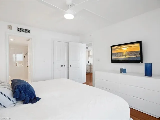 Bedroom with wood finished floors, a ceiling fan, and a closet